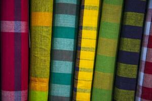 Multicolor Traditional Bangladeshi men's wear lungi folded on a rack in a store. Can be used as  pattern texture background wallpaper photo