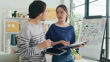 två ung asiatisk börja företag partners håller inte med yttranden argumentera i små företag kontor, besviken vinst marknadsföring planen jobb, och frilans arbete som e-handel entreprenör och medarbetare team. video