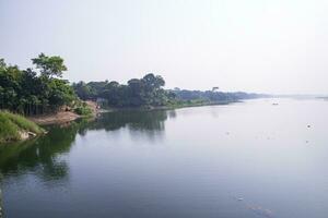 reflexión de arboles en el lago agua en contra el azul cielo paisaje campo en Bangladesh foto