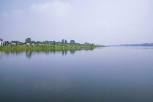 reflexión de arboles en el lago agua en contra el azul cielo paisaje campo en Bangladesh foto