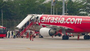 Phuket, Thailand Februar 27, 2023 Passagier einsteigen. Flugzeug auf das Flugplatz, Handy, Mobiltelefon Treppe. Menschen und Flughafen Mitarbeiter auf das Asphalt. billiger von Airasia. Reise Konzept video