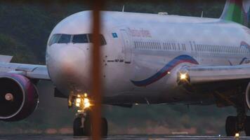 phuket, Tailandia enero 23, 2023 boeing 767 de domingo aerolíneas rodaje a phuket aeropuerto, ver mediante el cerca. imágenes de avión en el calle de rodaje delantal, avión. aire viaje y turismo concepto video