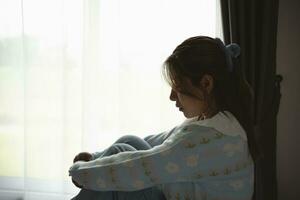 Silhouette depressed woman sadly sitting on the bed in the bedroom. Sad asian women suffering depression insomnia awake and sit alone on the bed in bedroom. Depression health people concept. photo