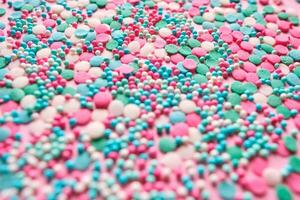 Multi-colored confectionery topping on a pink. photo