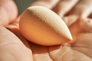 Small sponge in a woman's hand. photo