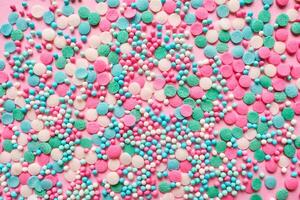 Multi-colored confectionery topping on a pink. photo