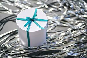 White box with a gift in tinsel. photo