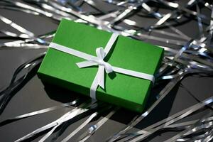 Green box with gifts on a gray background. photo