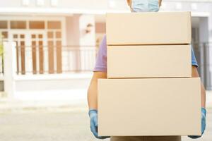 parcel delivery man of a package through a service. and close up hand customer female accepting a delivery of boxes from delivery man postal send direct to home. photo