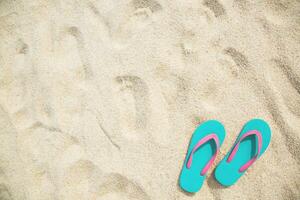 slipper of foot in sandals shoes and Blue ocean wave water distribution on sandy white beach, Sea background.The color of the water and beautifully bright. travel nature holiday summer concept. photo