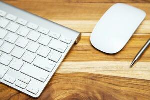 Modern aluminum computer keyboard of a laptop and Hard disk on the desk office wood. technology Electronic Devices. photo