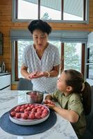 Grandmother and granddaughter preparing meatballs. photo