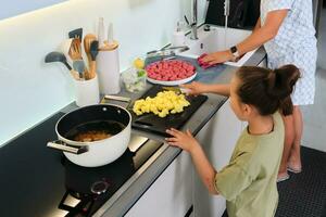 abuela y nieta son preparando sopa. foto