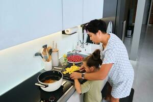 abuela y nieta son preparando sopa. foto