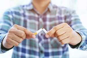 Man refusing cigarettes concept for quitting smoking and healthy lifestyle dark background. or No smoking campaign Concept. photo