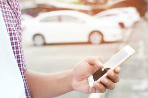 close up businessman hand using a mobile smart phone call a car mechanic ask for help assistance because car broken roadside. people journey friends standing wait beside broken car background. photo