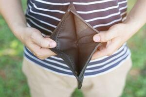 Unhappy bankrupt woman with empty wallet . Young woman shows her empty wallet. Bankruptcy photo