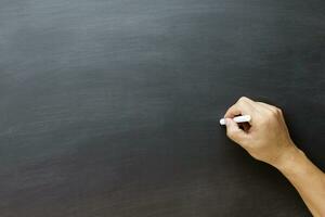 young teen hand to draw and writing something on blackboard photo