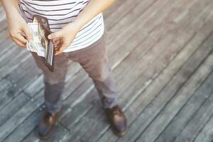 Hipster man hands holding wallet with credit cards and stack of money. photo