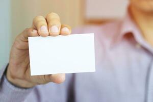 Hand hold blank white card mockup with rounded corners. Plain call-card mock up template holding arm. photo