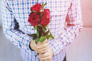 un hombre con un rojo Rosa para un Novia en San Valentín día foto