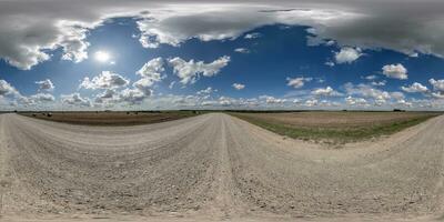 360 hdri panorama on white sand wet gravel road with marks from car or tractor tires with clouds on blue sky in equirectangular spherical  seamless projection, skydome replacement in drone panoramas photo