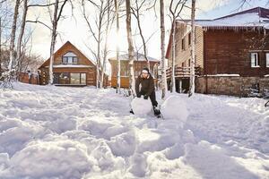 A family builds a snowman out of white snow in the yard in winter. photo