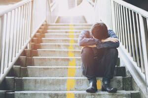 man sitting staircase way pedestrian overpass. stress people compression in office feel stressful can't make decision jobless or depression situation Stress cause mental problems Stress Concept photo