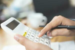 Unrecognizable businessman using calculator photo