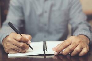 male hands with pen writing on notebook photo