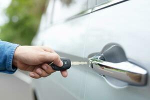 Cropped view of  Closeup of a man's hand inserting key into the door lock of a car photo