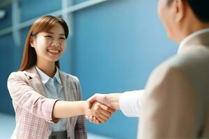 Asian girl shaking hands with blurred elderly woman photo