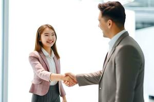 Asian young woman shaking hands with businessman photo