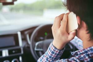 close up person man using mobile smart phone call while driving car travel on the road. photo