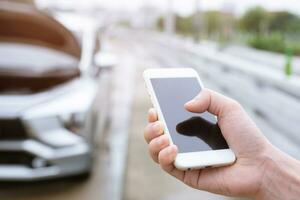 close up businessman hand using a mobile smart phone call a car mechanic ask for help assistance because car broken roadside. people journey friends standing wait beside broken car background photo