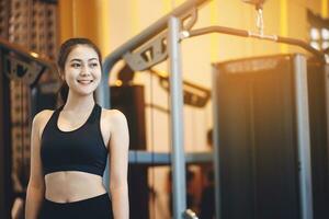 asiático mujer hacer ejercicio a perder peso a el gimnasio foto