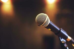 Close up of microphone on stage lighting at concert hall or conference room. copy space banner. soft focus. photo