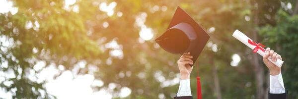 graduate are celebrating graduation. Happiness feeling hand hold show hat and diploma certificate in background sky.  Congratulation education during Commencement day University Degree. photo