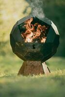 a fire pit sitting on top of grass photo