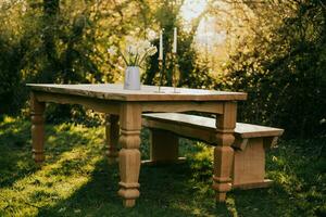 a table and bench in the middle of a field photo