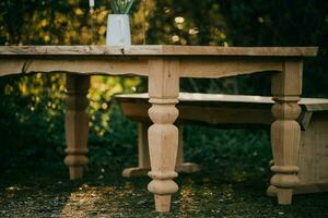 a table with two benches sitting in the woods photo