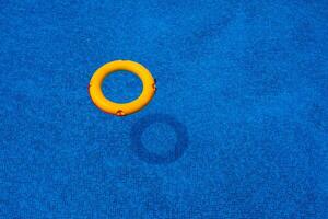 Top view of lifebuoy floating in blue swimming pool, soft focus. photo