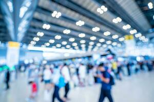 Blurred images of trade fairs in the big hall. image of people walking on a trade fair exhibition or expo where business people show innovation activity and present products in a big hall. photo