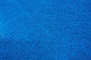 ligero refleja apagado el superficie de el azul nadando piscina. foto