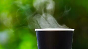 coffee takeaway in a paper cup on top of the car roof green tree background at sunrise in the morning,  selective focus, soft focus. photo