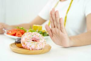 dieta y dieta. belleza cuerpo femenino delgado confundir donut. mujer con ropa de ejercicio logra el objetivo de pérdida de peso para una vida saludable, loca por la delgadez, cintura delgada, nutricionista. foto