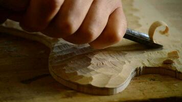 Luthier manufacturing a instrument with a chisel video