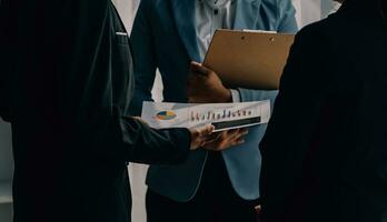 Financial analysts analyze business financial reports on a digital tablet planning investment project during a discussion at a meeting of corporate showing the results of their successful teamwork. photo