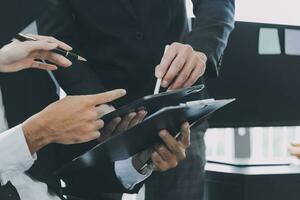 Business team working with new startup project plan and discussion information for financial strategy with laptop and digital tablet in a modern business lounge. photo