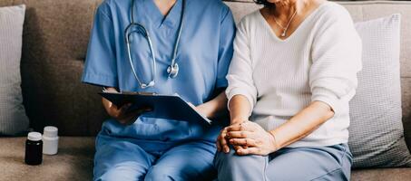 cuidando médico enseña hembra paciente a utilizar móvil cuidado de la salud aplicación retirado dama sentado en hospital examen habitación mirando a célula pantalla aprendizaje a descargar salud rastreador para mayor los ciudadanos. Copiar espacio foto